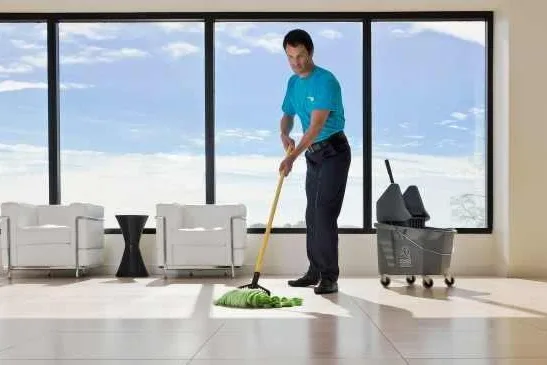 Cleaner mopping an office floor
